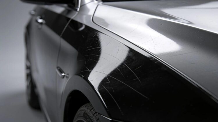 Close-up of luxury vehicle paint defects including scratches and swirl marks
